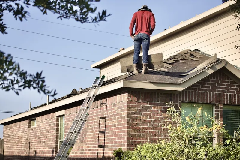 Professional roofer working on a residential roof in Swepsonville